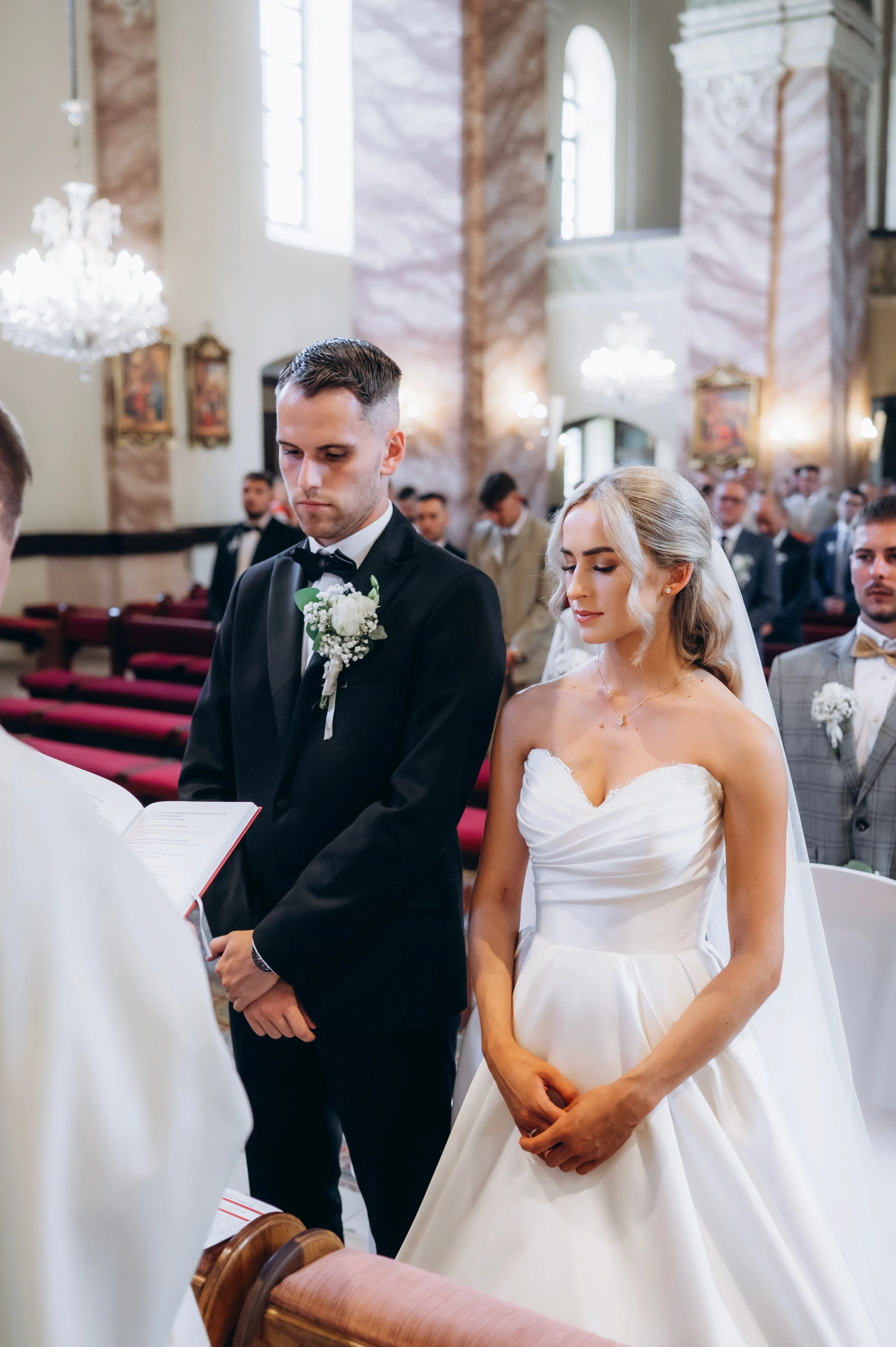 Novomanželia stoja pri oltári počas cirkevného obradu.