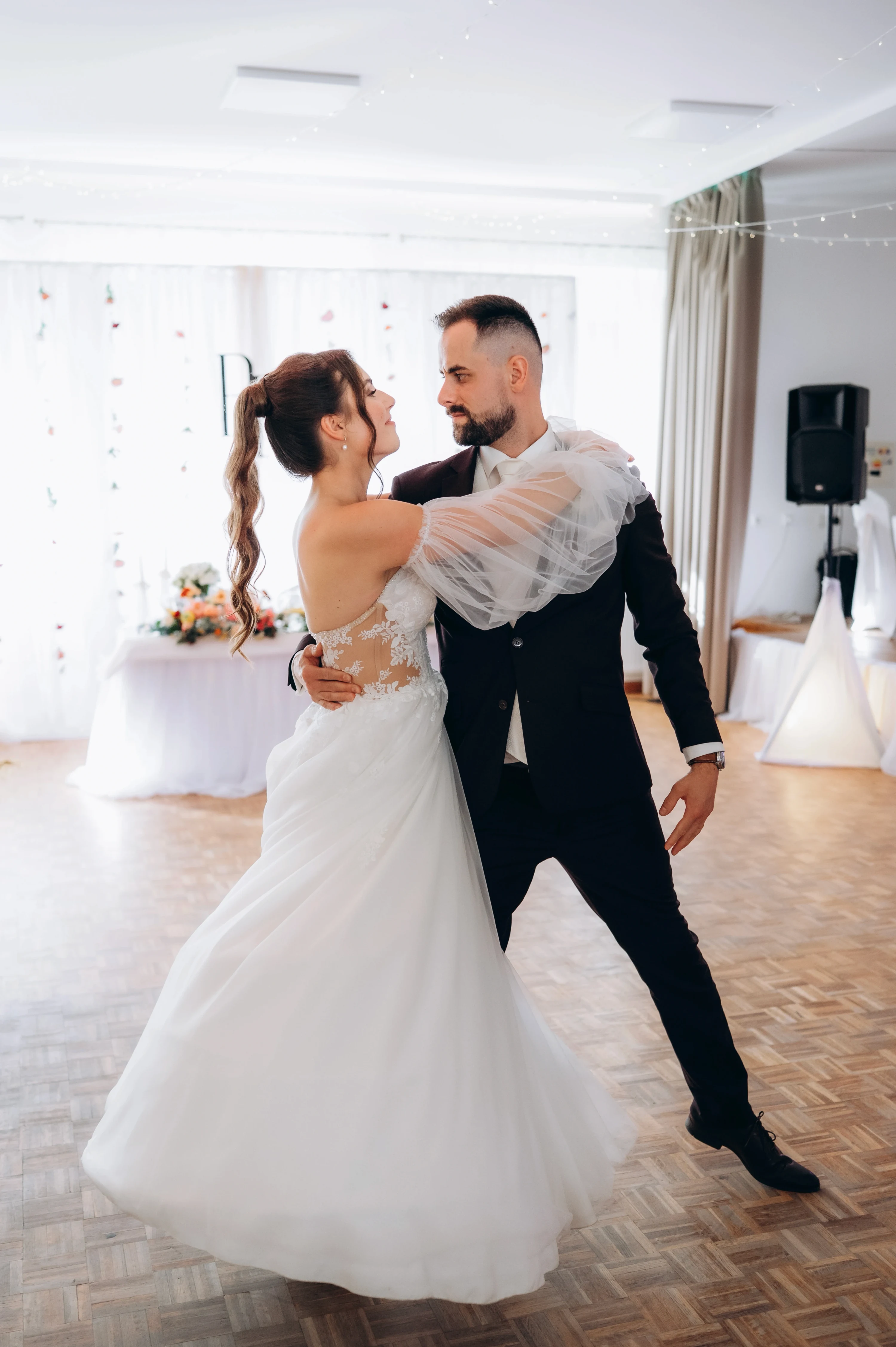 Prvý tanec: novomanželia sa nežne objímajú na recepcii.