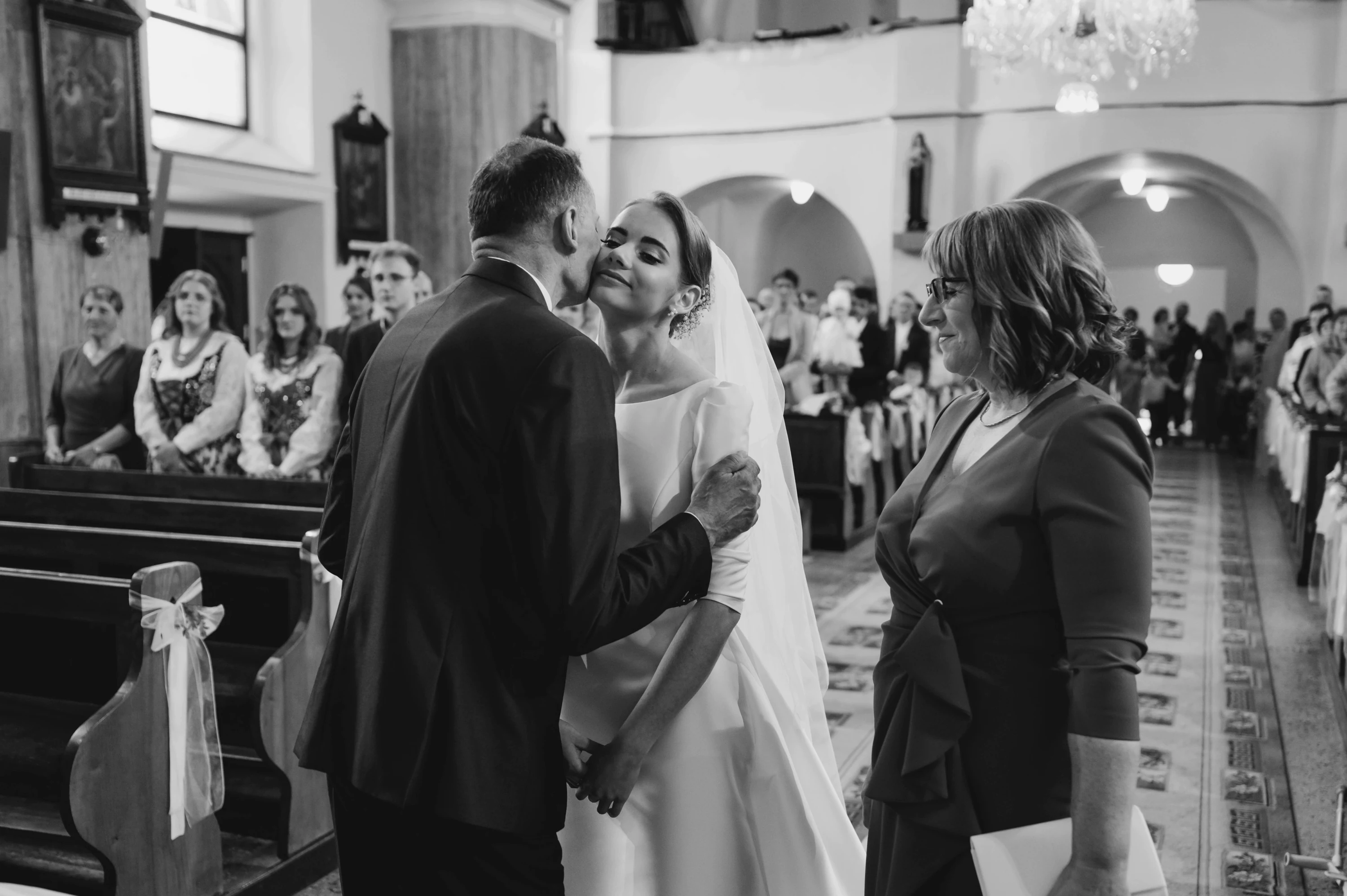 Magdaléna a Ľubomír objíma svoju partnerku zozadu pri západe slnka.