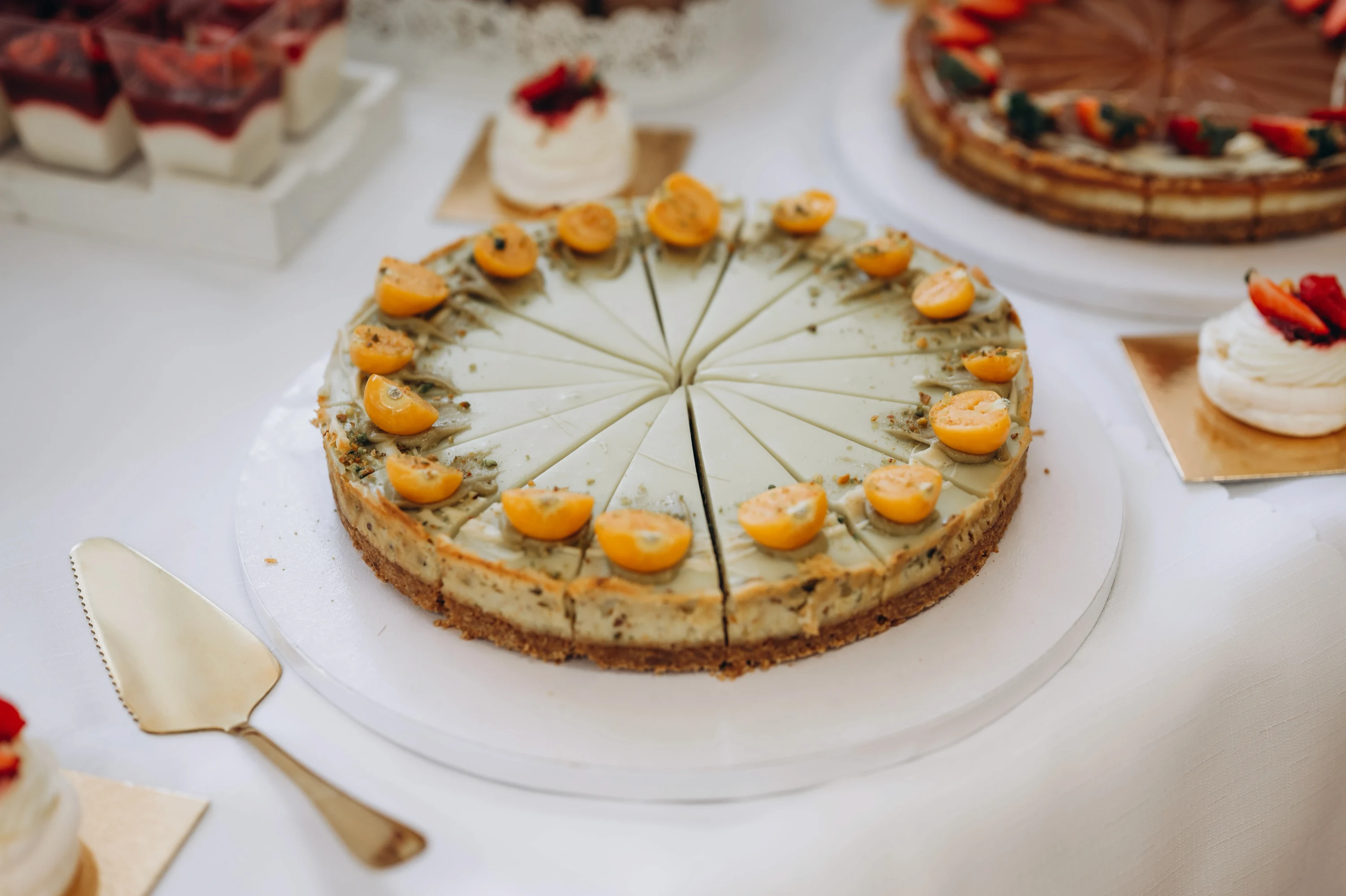 Svadobná torta rozdelená na plátky s marhuľovými guľôčkami na bielom tanieri.