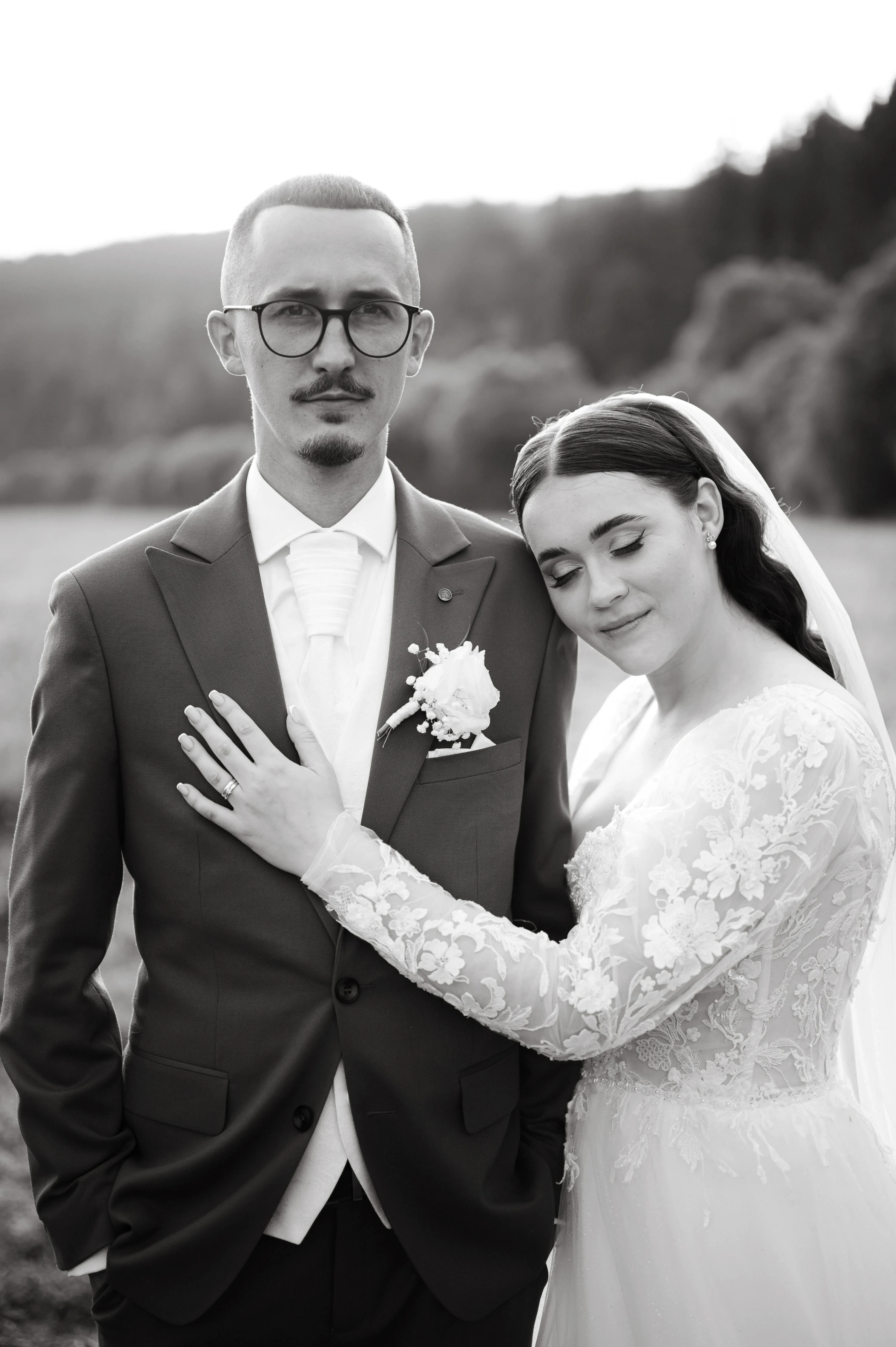 Čiernobiely portrét nevesty a ženícha v emotívnej chvíli.