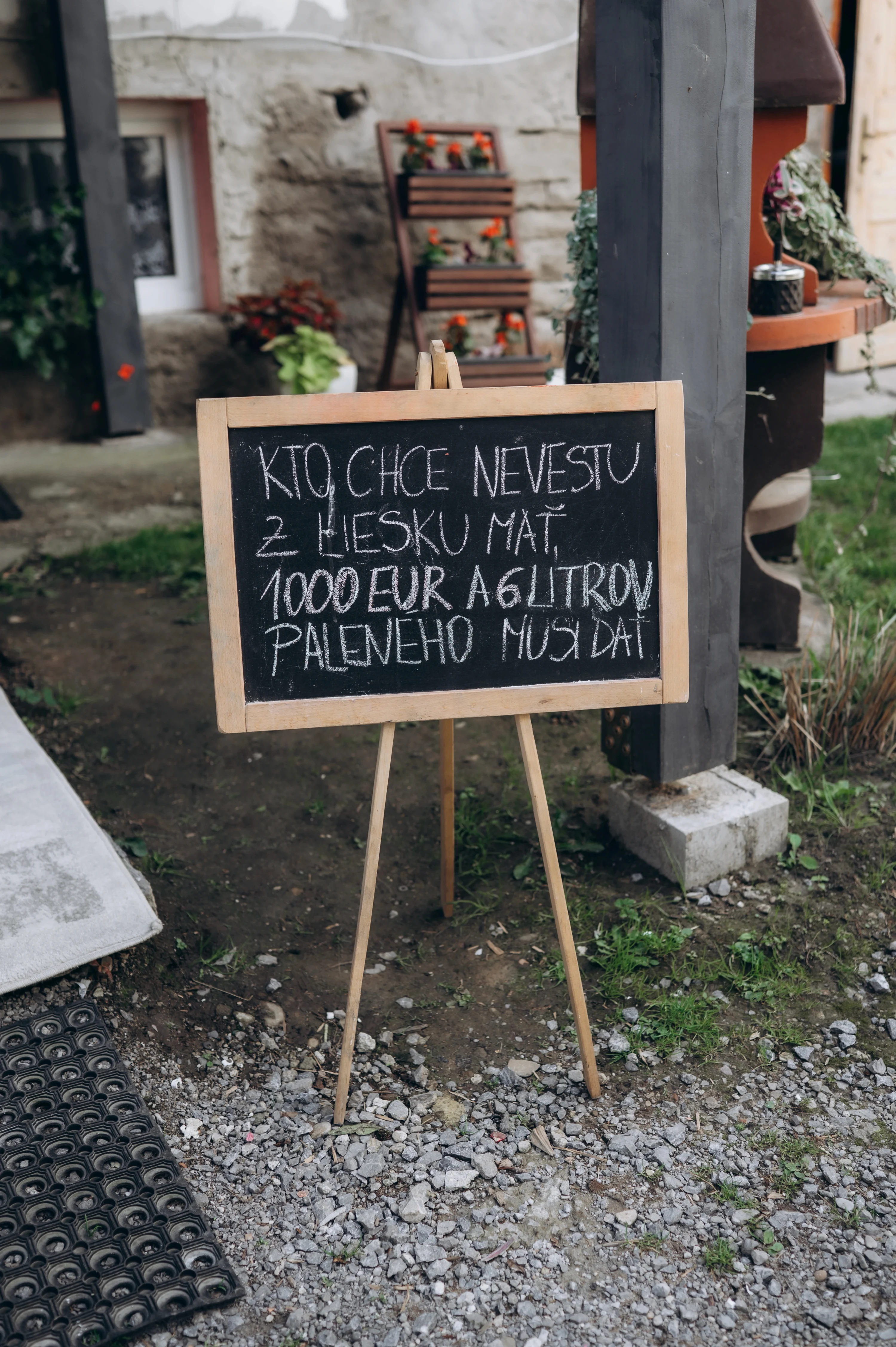Tabuľa s vtipným odkazom pre ženícha pri vchode na svadbu.