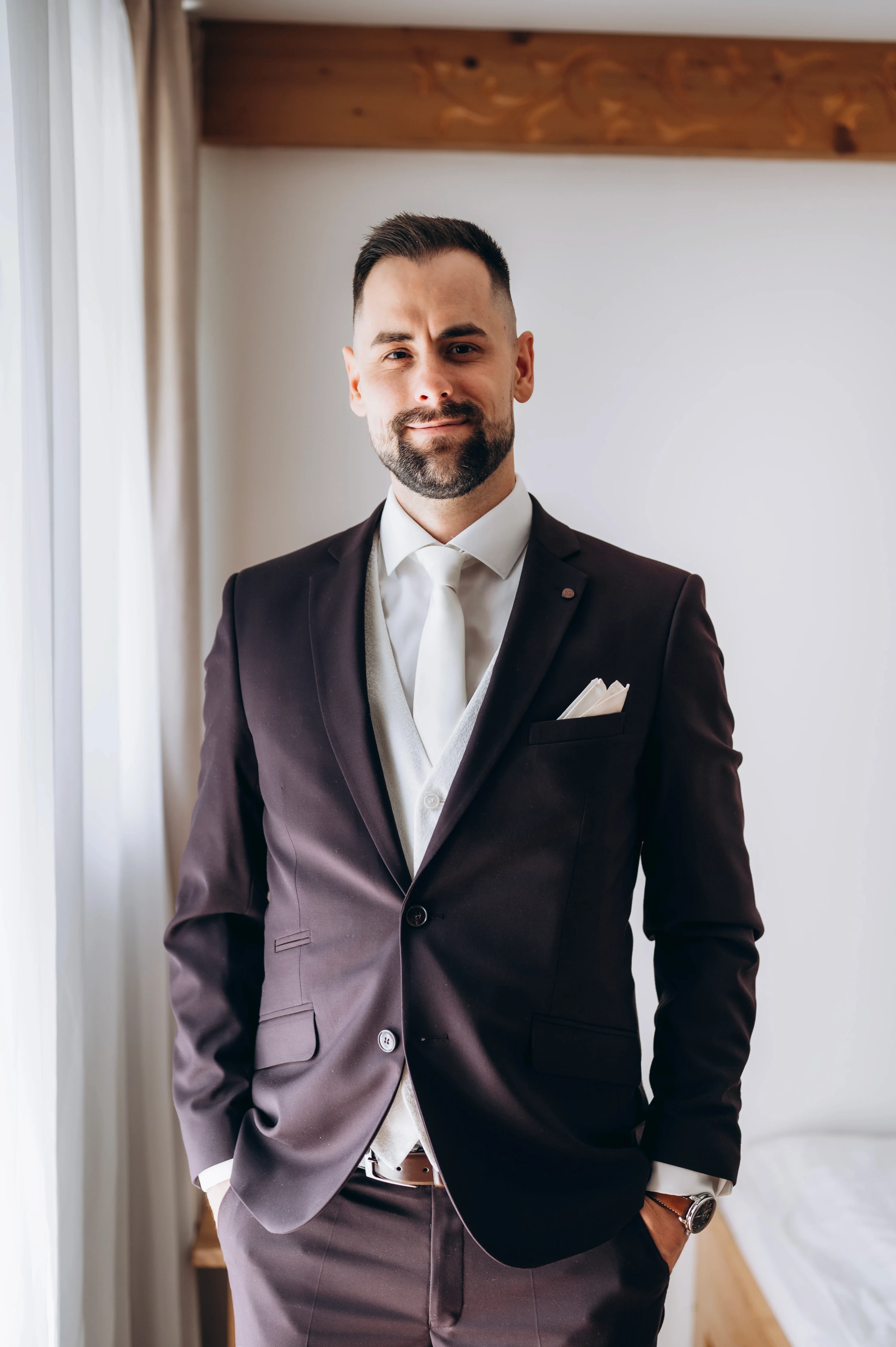 Portrét ženícha v elegantnom obleku s vreckovkou v interiéri.