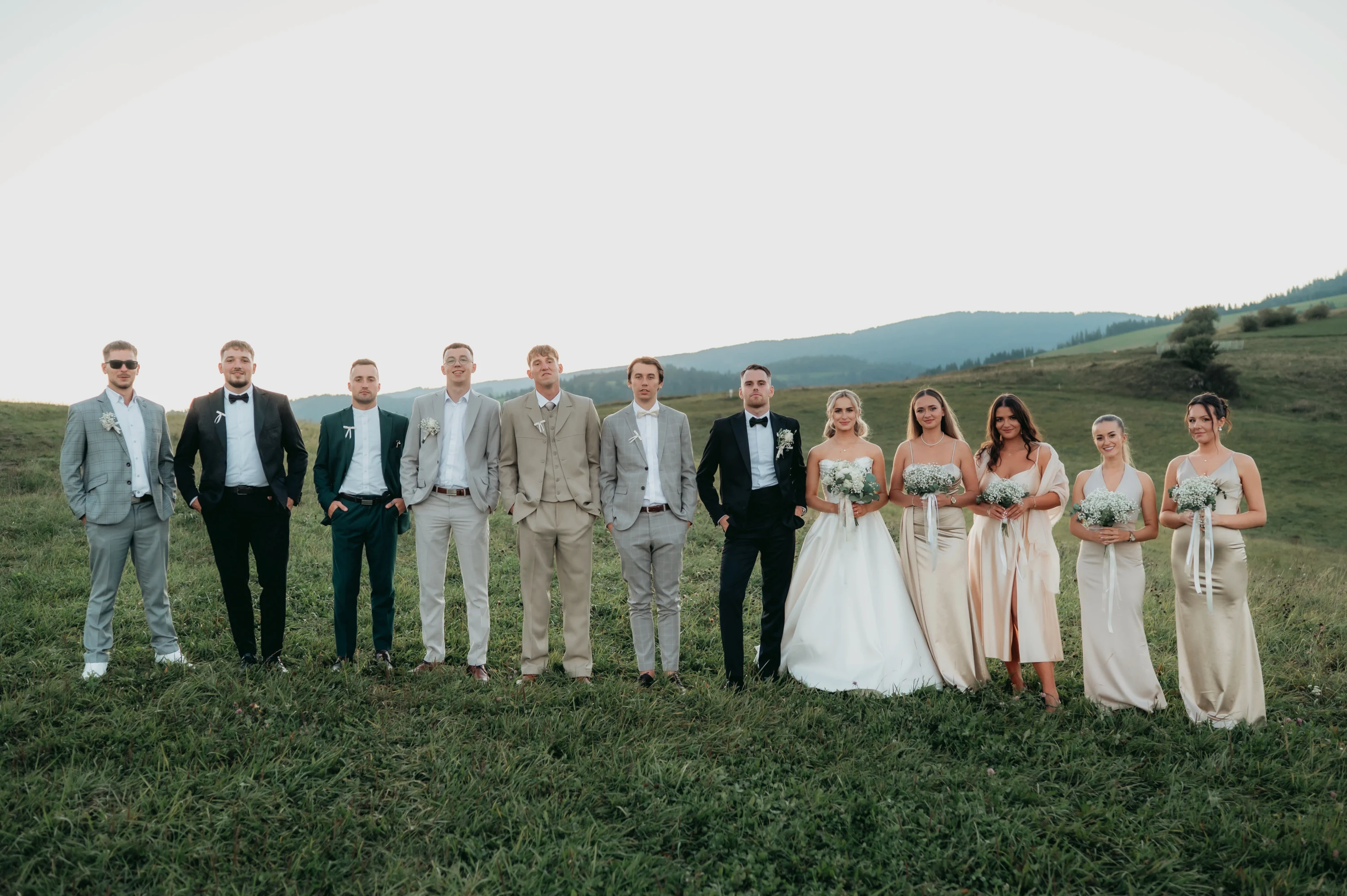 Novomanželia s rodinou a hosťami na poslednej spoločnej fotografii.