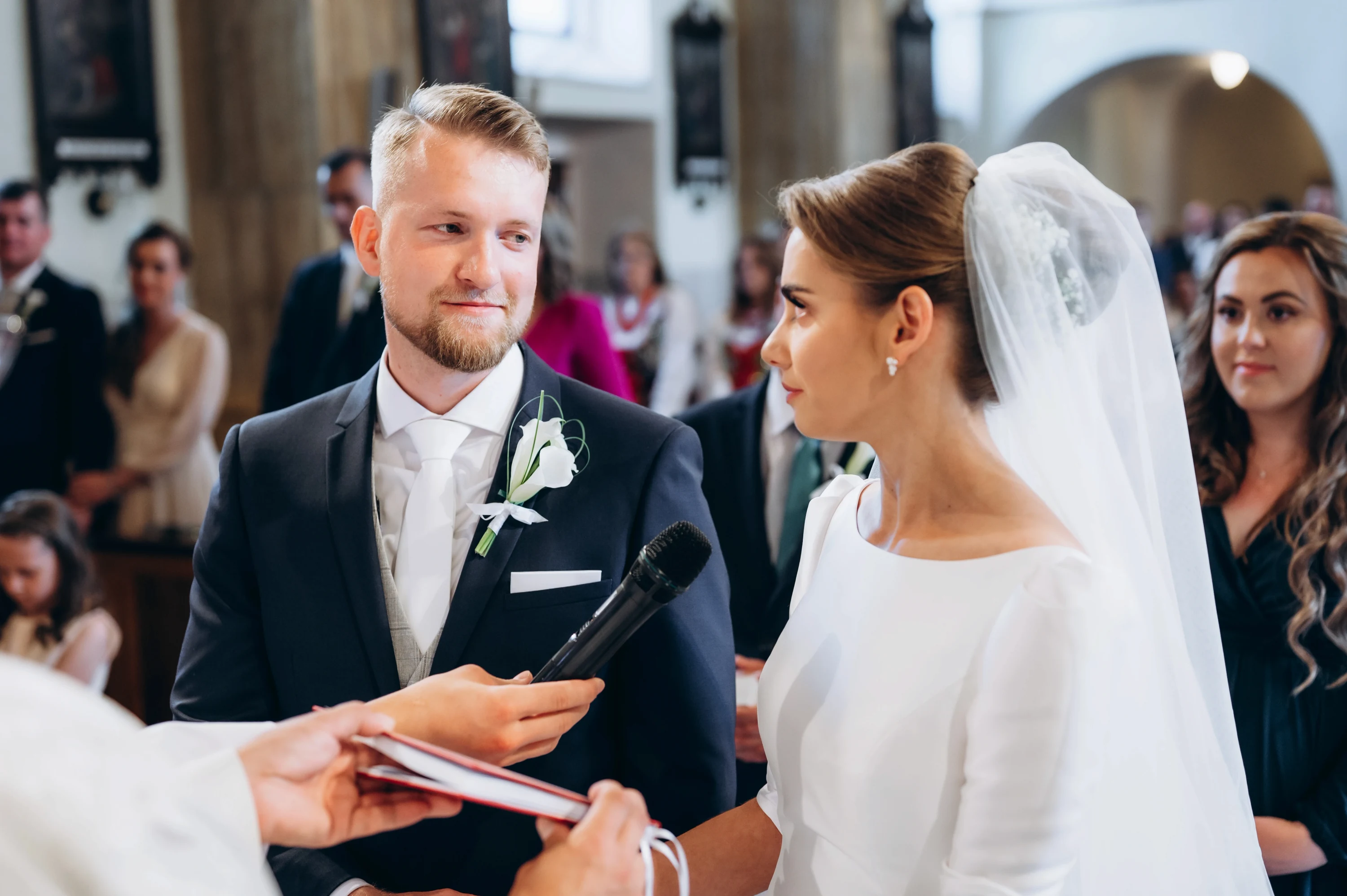 Počas svadobného obradu si pár vymieňa sľuby pred kňazom v chráme.