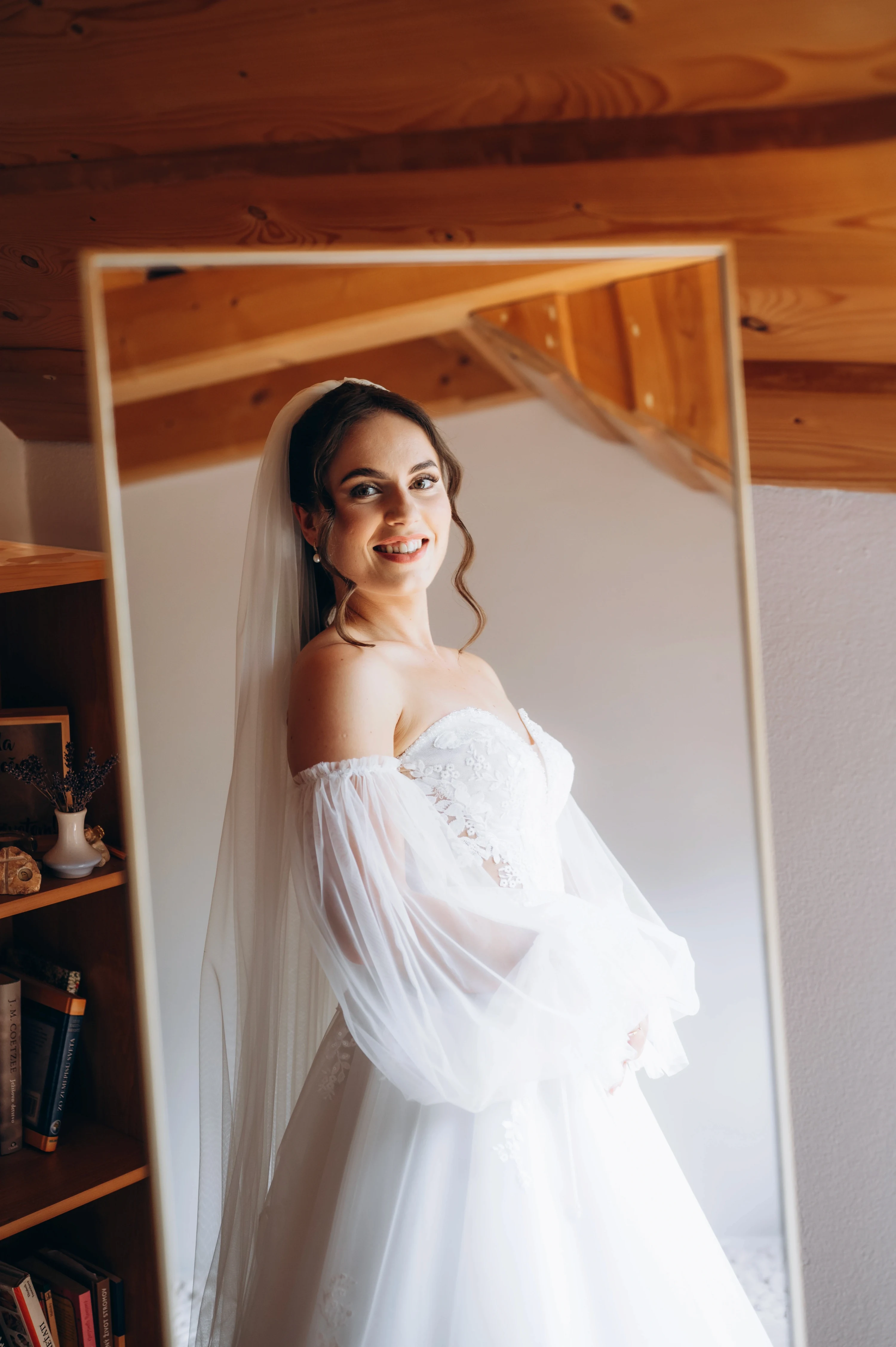 Nevesta sa obracia k zrkadlu a prezerá si svoje biele šaty.