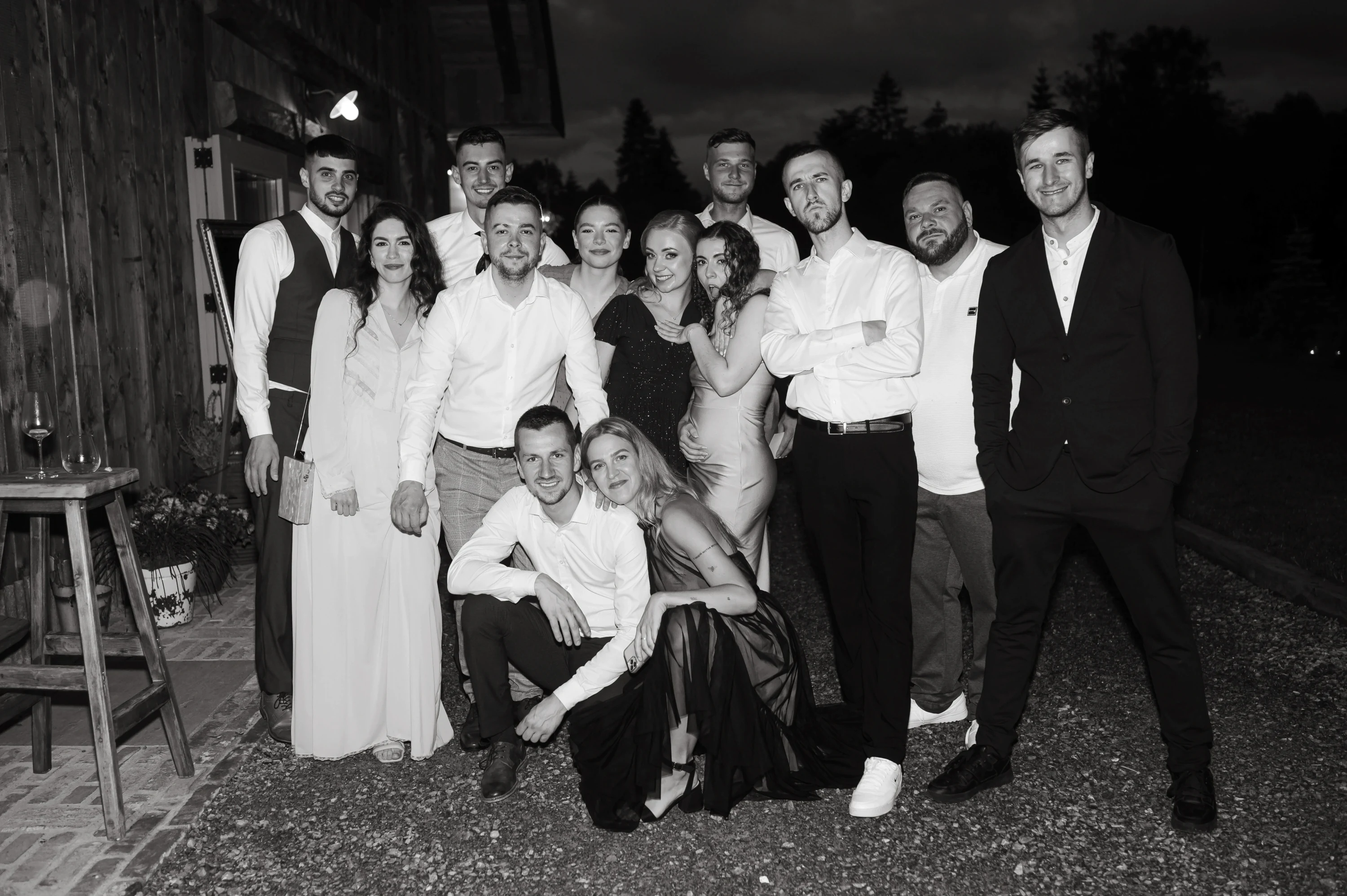 Skupinová fotografia hostí na svadbe počas večerného veselia.